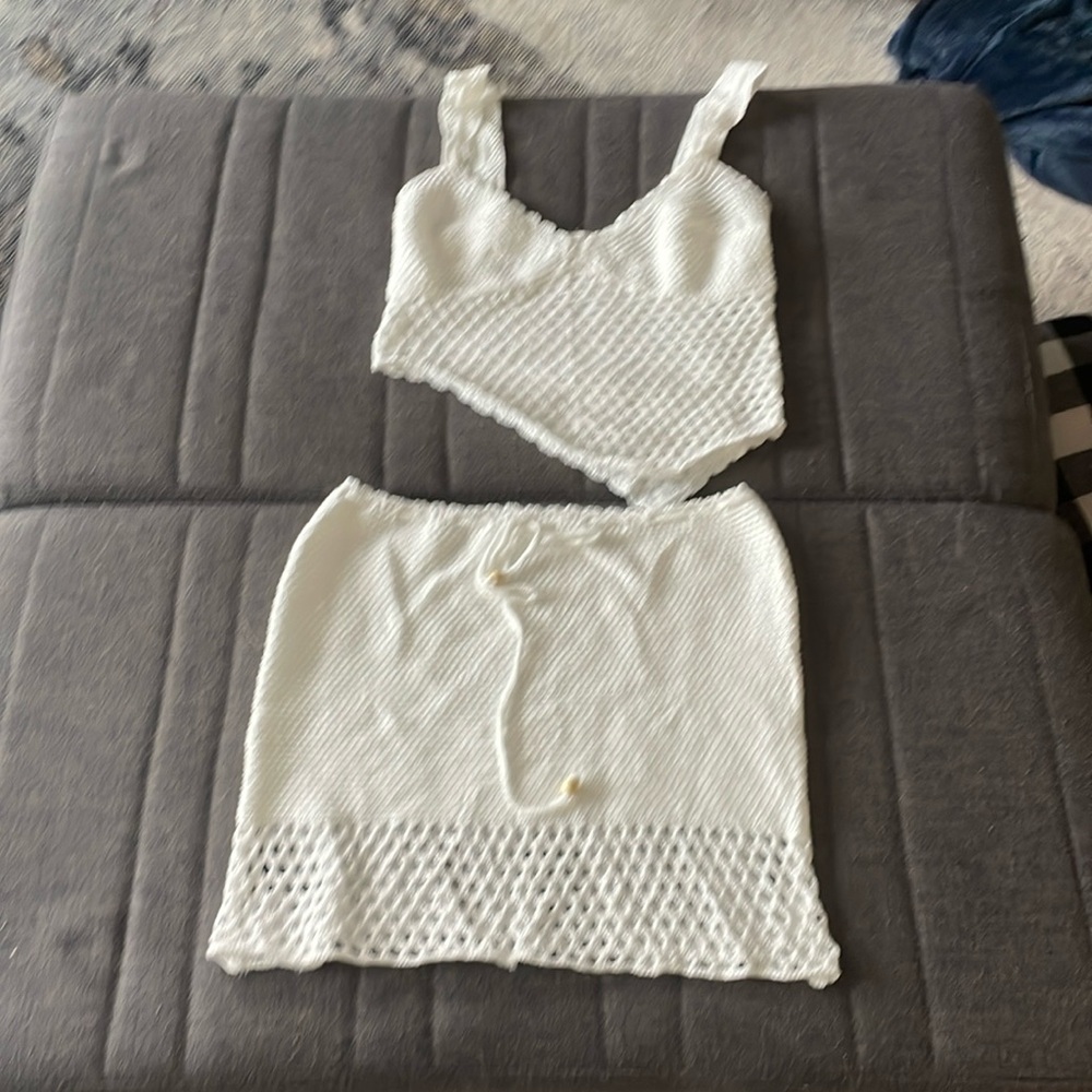 Two piece white crochet asymmetrical top and skirt set
